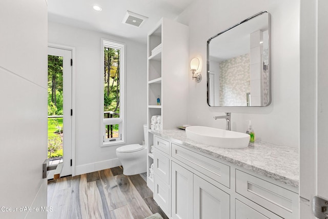 172 Elk Hills Rd, Sandpoint, ID 83864 - bathroom featuring vanity, toilet, wood finished floors, and baseboards