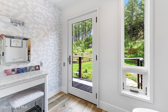 172 Elk Hills Rd, Sandpoint, ID 83864 - doorway to outside featuring wallpapered walls, baseboards, light wood-style floors, and an accent wall