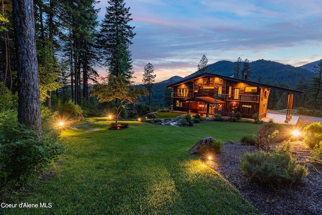 172 Elk Hills Rd, Sandpoint, ID 83864 - back of property featuring a lawn, a chimney, a deck with mountain view, and a carport
