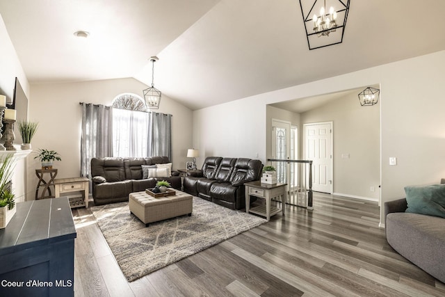 living room with an inviting chandelier, baseboards, wood finished floors, and lofted ceiling