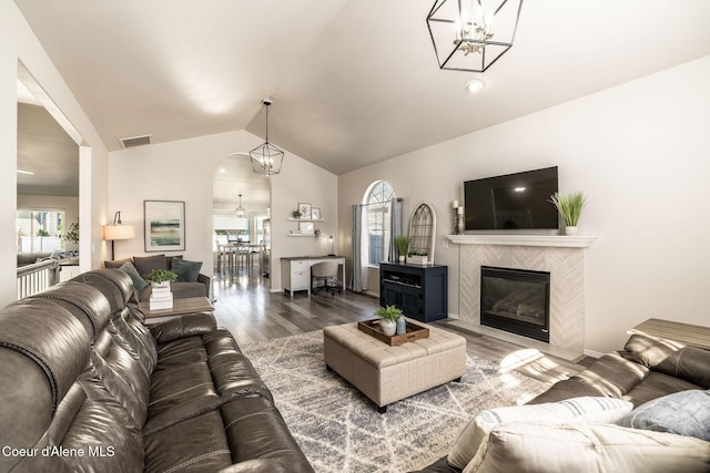 living room with visible vents, arched walkways, a notable chandelier, and dark wood-style floors