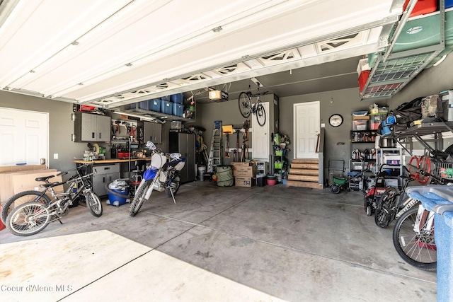 garage with a garage door opener and a workshop area