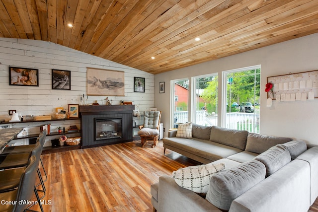 living room featuring wood walls, vaulted ceiling, wooden ceiling, and wood finished floors