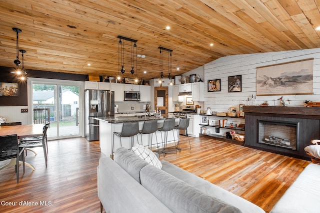 living room with wood finished floors, wood ceiling, lofted ceiling, and wooden walls