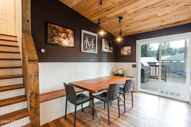 dining room featuring wainscoting, wooden ceiling, wood finished floors, vaulted ceiling, and stairway