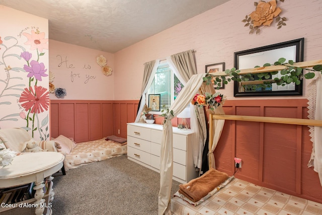 bedroom with light colored carpet and a textured ceiling