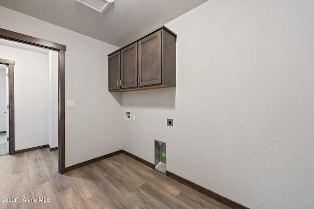 24903 N Old Highway 95, Athol, ID 83801 - laundry area featuring hookup for an electric dryer, light wood finished floors, washer hookup, a textured ceiling, and cabinet space