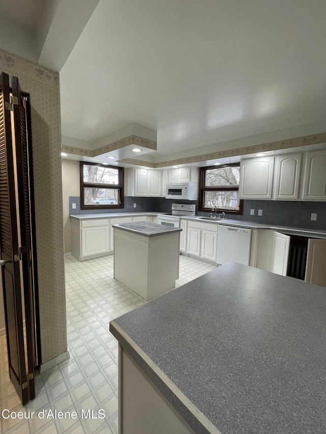 6990 Denver St, Bonners Ferry, ID 83805 - kitchen with a sink, white appliances, a center island, light floors, and tasteful backsplash