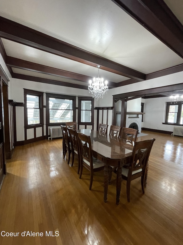 6990 Denver St, Bonners Ferry, ID 83805 - dining area featuring beam ceiling, a notable chandelier, radiator heating unit, and hardwood / wood-style flooring