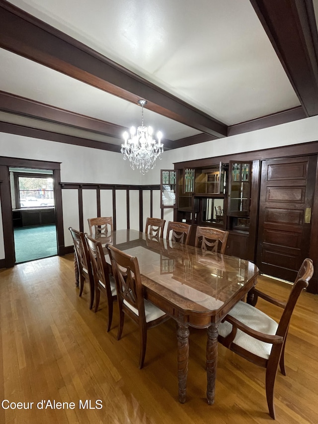 6990 Denver St, Bonners Ferry, ID 83805 - dining room featuring an inviting chandelier, wood finished floors, and beam ceiling