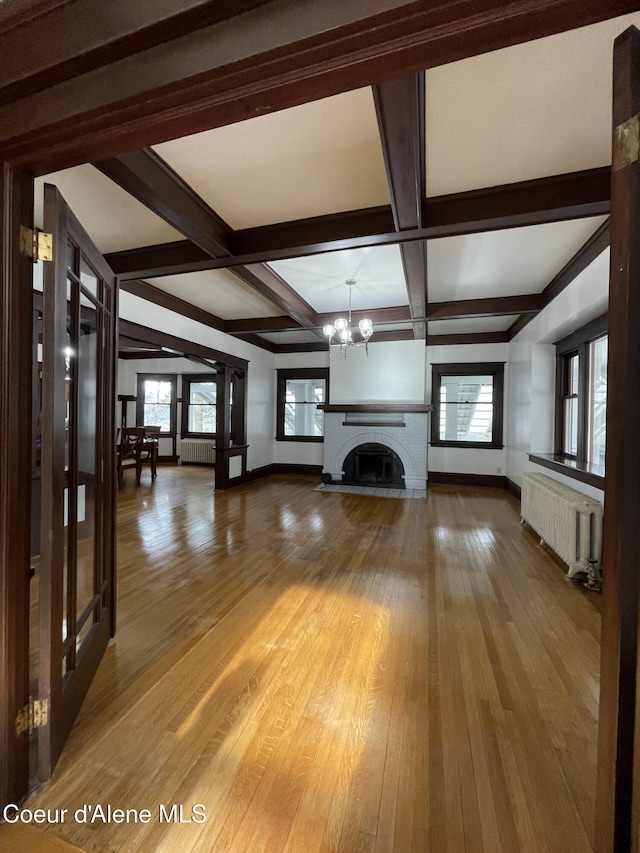 6990 Denver St, Bonners Ferry, ID 83805 - unfurnished living room with an inviting chandelier, radiator, baseboards, and beam ceiling
