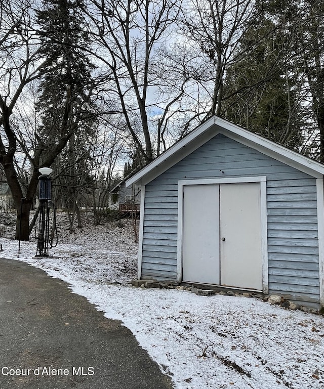 6990 Denver St, Bonners Ferry, ID 83805 - snow covered structure featuring a storage shed and an outbuilding