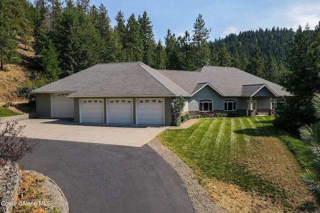 1358 S Starlight Dr, Coeur Dalene, ID 83814 - ranch-style house featuring a front lawn, aphalt driveway, a shingled roof, an attached garage, and a view of trees