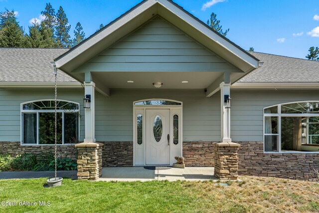1358 S Starlight Dr, Coeur Dalene, ID 83814 - view of front of house with a front yard, a shingled roof, and stone siding