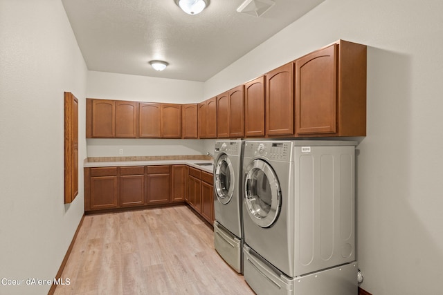 1358 S Starlight Dr, Coeur Dalene, ID 83814 - washroom featuring cabinet space, a sink, baseboards, light wood-style floors, and separate washer and dryer
