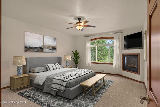 1358 S Starlight Dr, Coeur Dalene, ID 83814 - carpeted bedroom with baseboards, visible vents, a glass covered fireplace, and ceiling fan