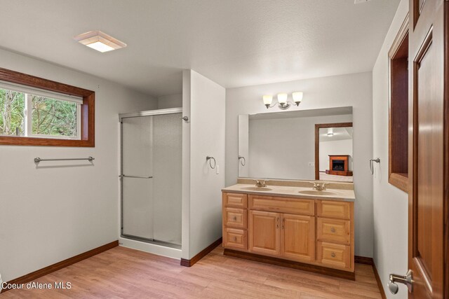 1358 S Starlight Dr, Coeur Dalene, ID 83814 - bathroom featuring a sink, double vanity, baseboards, wood finished floors, and a stall shower