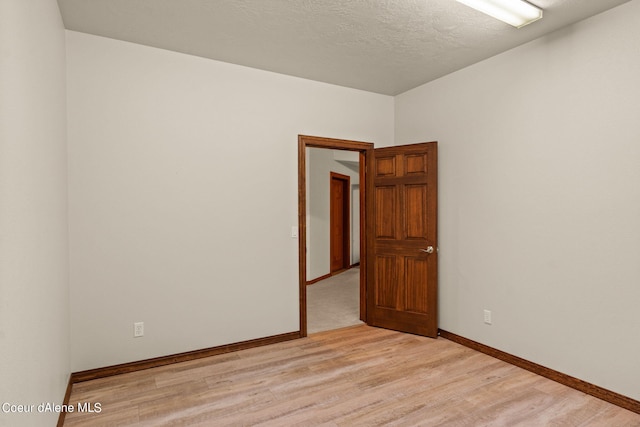 1358 S Starlight Dr, Coeur Dalene, ID 83814 - empty room with light wood-style floors, a textured ceiling, and baseboards