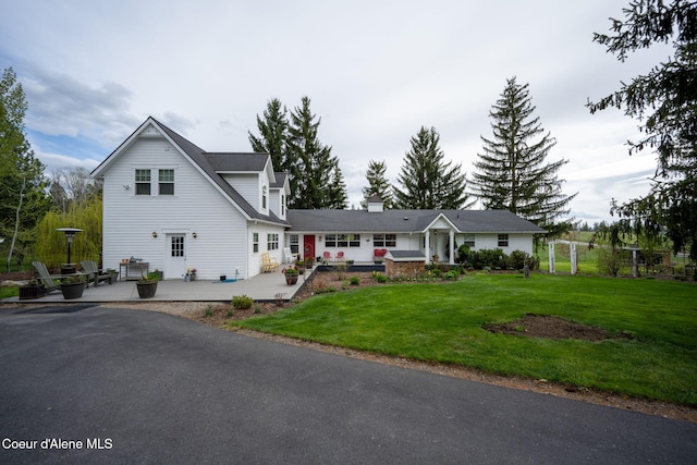 traditional-style house with a patio area and a front yard