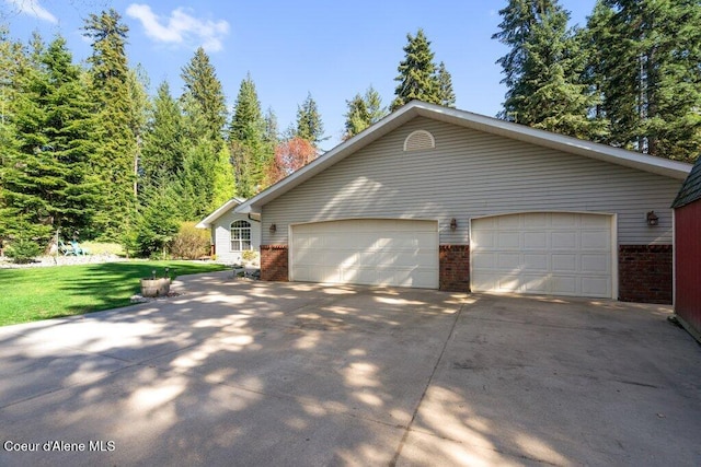 view of side of property with a lawn, driveway, and brick siding