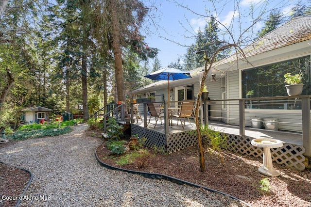 rear view of house featuring a deck and an outdoor structure