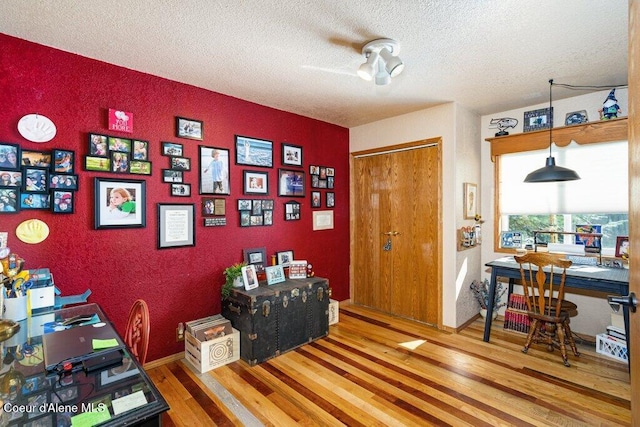 home office featuring a textured ceiling and wood finished floors