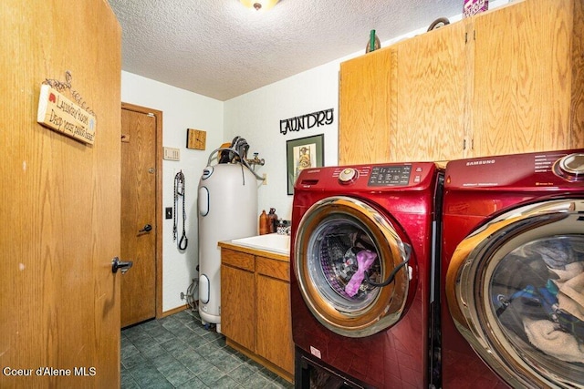 laundry room with a textured ceiling, water heater, washing machine and dryer, cabinet space, and dark floors