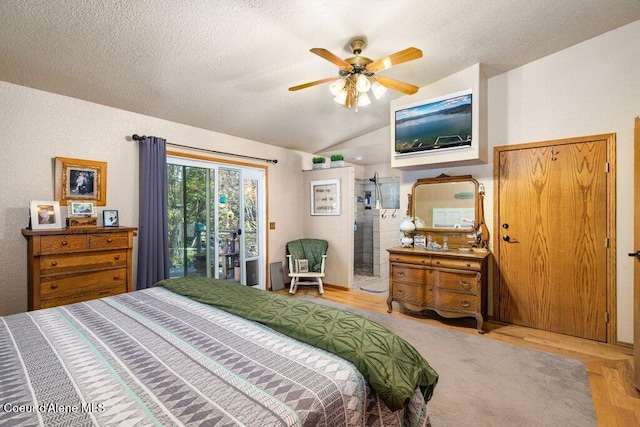 bedroom featuring access to outside, a textured ceiling, a ceiling fan, wood finished floors, and vaulted ceiling