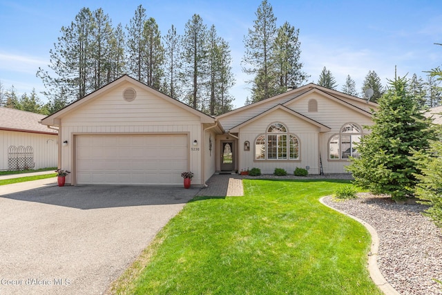 view of front of property with an attached garage, a front lawn, and aphalt driveway