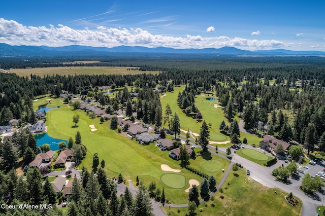 bird's eye view featuring a water and mountain view, view of golf course, and a view of trees