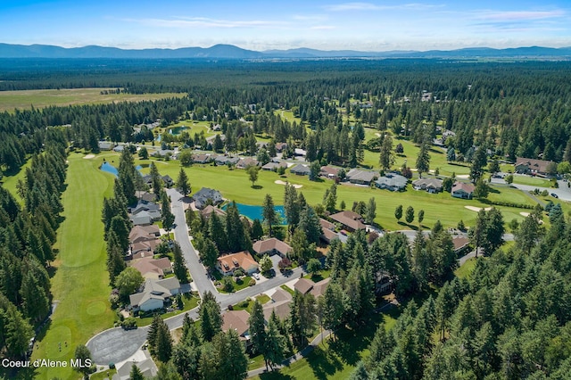 aerial view featuring a view of trees and a water and mountain view