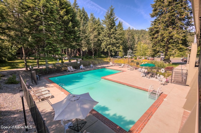 community pool featuring fence and a patio