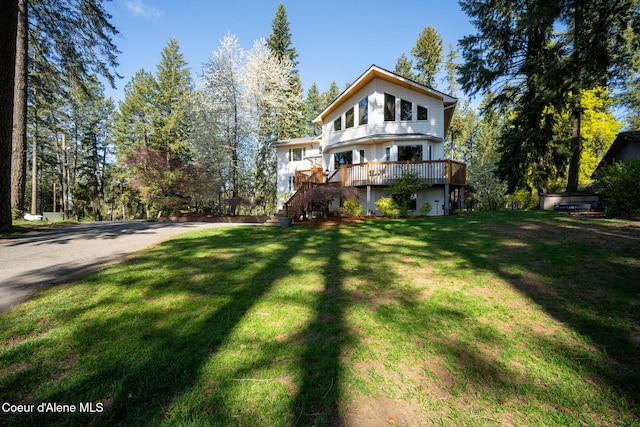 back of property featuring a lawn and a deck