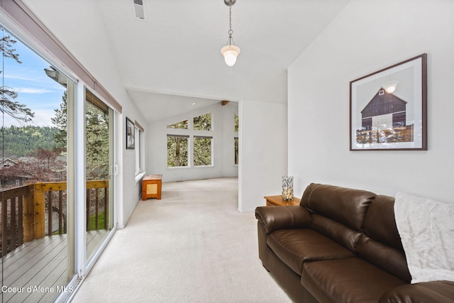 living area featuring visible vents, lofted ceiling, and light carpet