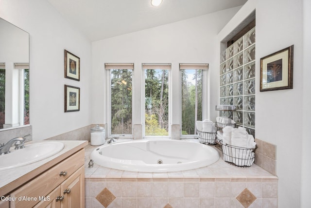 full bathroom featuring a whirlpool tub, vaulted ceiling, and vanity