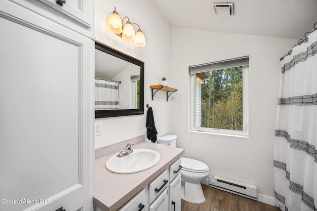 full bath with visible vents, vanity, toilet, wood finished floors, and a baseboard heating unit