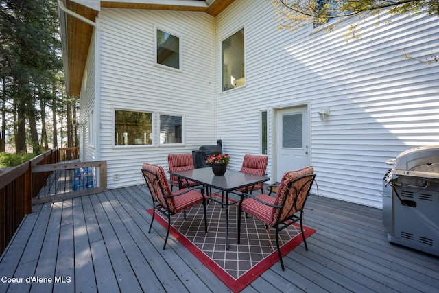 wooden deck with outdoor dining space and a grill