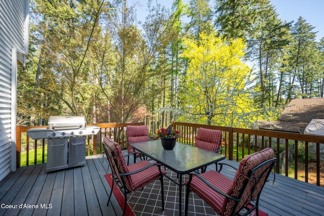 wooden terrace featuring outdoor dining area and a grill