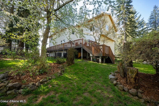 back of property featuring a wooden deck, fence, central AC unit, a lawn, and stairway