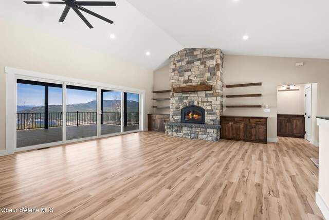unfurnished living room with ceiling fan, a fireplace, high vaulted ceiling, baseboards, and wood finished floors