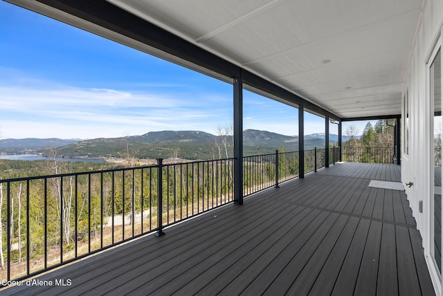 wooden terrace featuring a water and mountain view