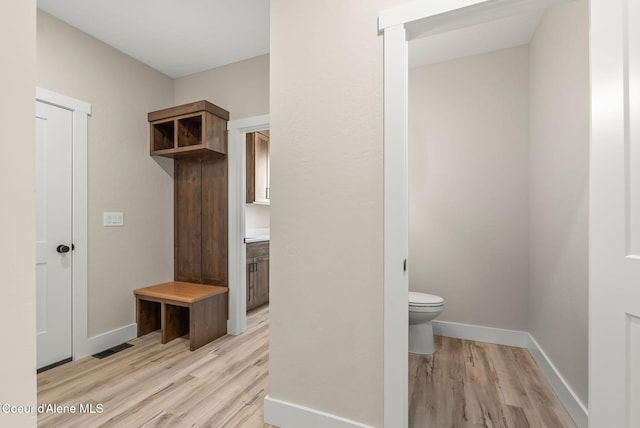 mudroom featuring baseboards, visible vents, and light wood-style floors