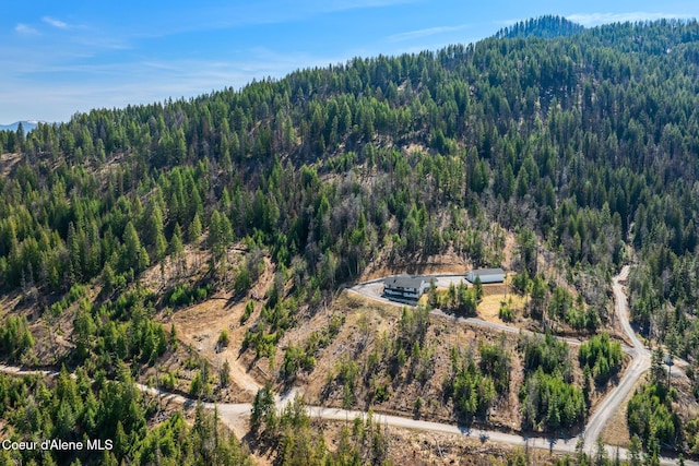 birds eye view of property featuring a mountain view and a wooded view