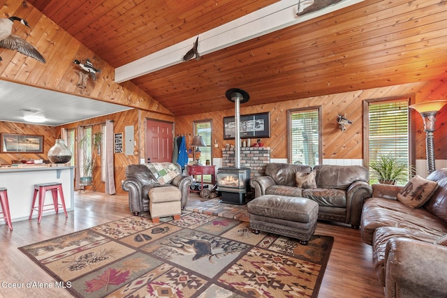333 E Cedar Ln, Priest River, ID 83856 - living room featuring a wood stove, wood walls, wood finished floors, and lofted ceiling with beams
