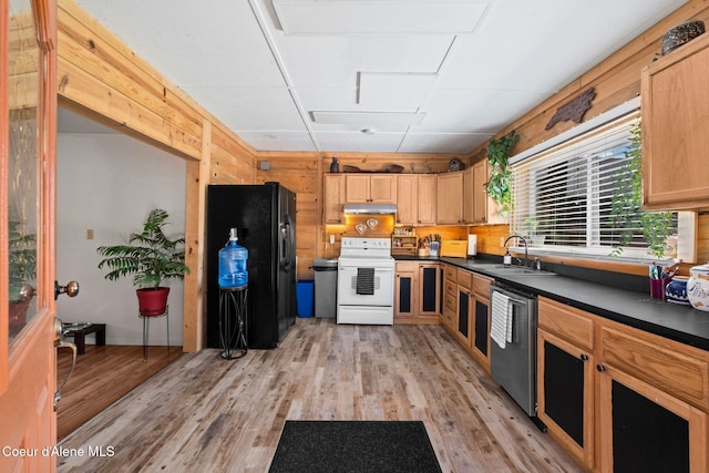 kitchen featuring black fridge, a sink, light wood finished floors, dishwasher, and white electric stove
