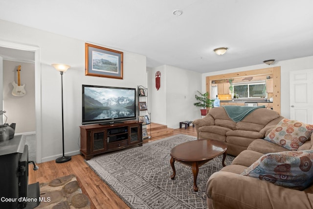 living area with baseboards and wood finished floors