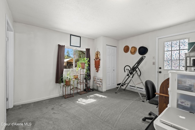 carpeted office space featuring a textured ceiling and baseboards