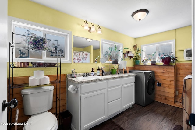 bathroom featuring vanity, washer / dryer, wood finished floors, and toilet