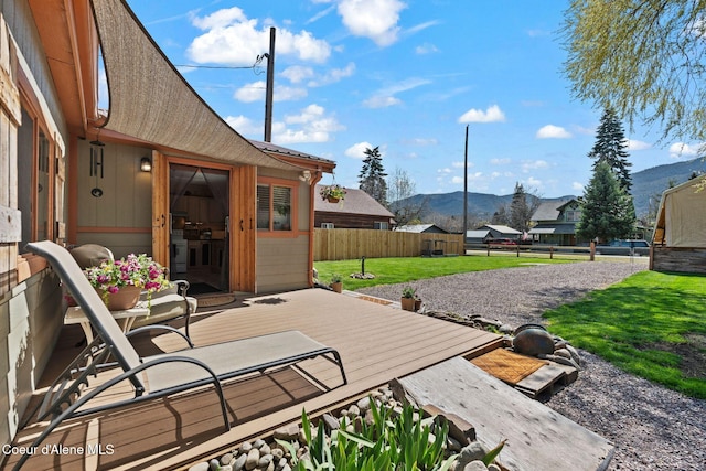 view of patio / terrace with a deck with mountain view and a fenced backyard