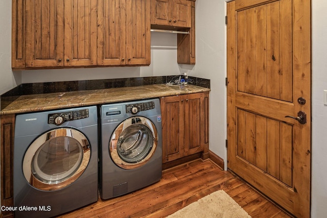 washroom featuring dark wood finished floors, cabinet space, and washer and dryer
